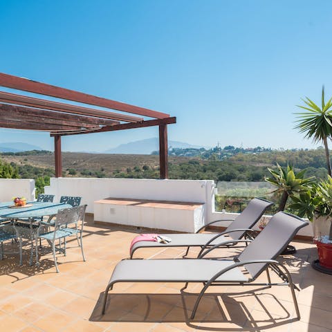 Top up your tan on the sun loungers with sweeping views of the Costa Del Sol