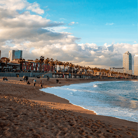 Wander the golden shores of Barceloneta Beach, a short bus ride away