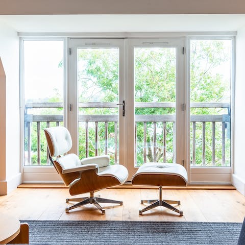 Relax in the Eames chair as you watch over the river