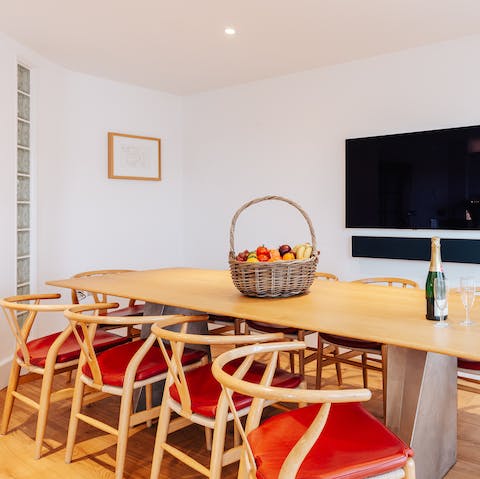 Gather together for meals at the beautiful dining table – a replica of a Jean Prouve design – with its  Wegner wishbone design chairs 