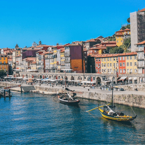 Stroll along the riverfront promenade at Cais da Ribeira, under fifteen minutes from your front door