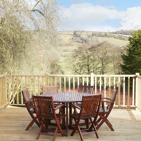 Admire the view of rolling hills and moors from the sunny dining deck