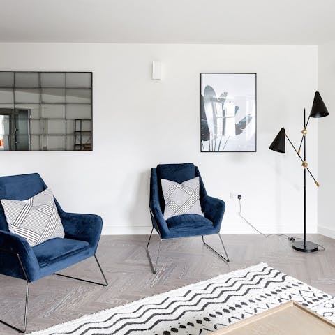 Unwind in a chic living space with velvet upholsteries and deep blue tones