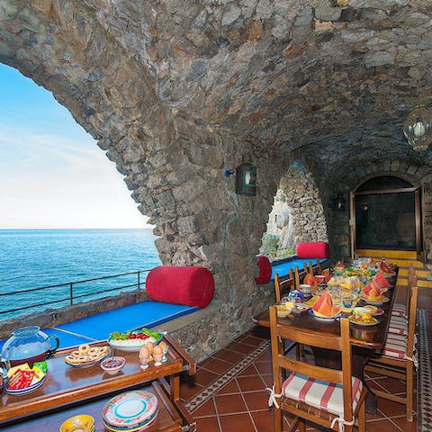 Enjoy alfresco meals with sea views visible through the arches
