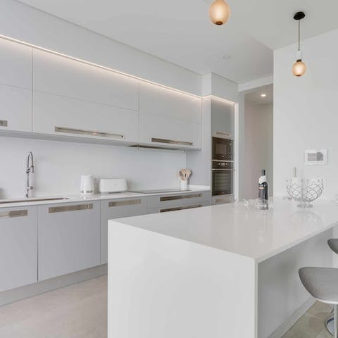 Cook up a storm in the sleek, white kitchen for a quiet day at the villa