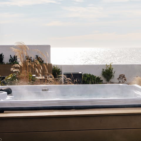 Admire the sea view from the hot tub before sitting next to the adjacent fire pit