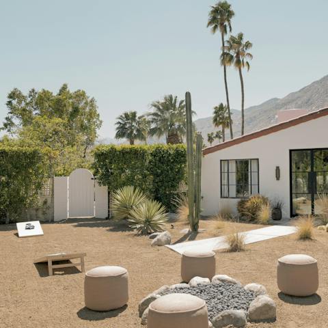 Gather round the firepit while the kids play some cornhole