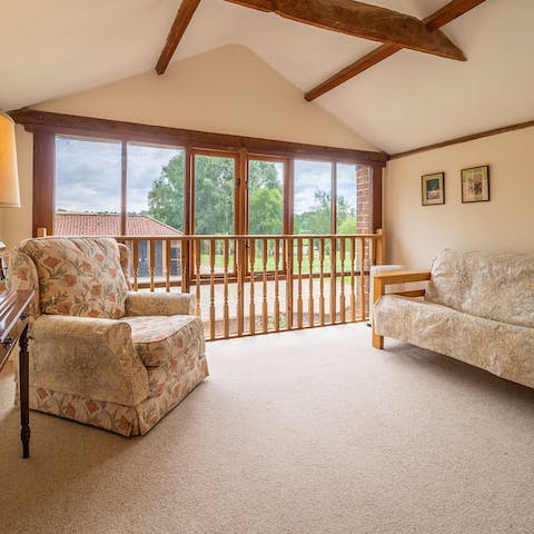 Relax in the upstairs sitting room with views of the stud and valley beyond