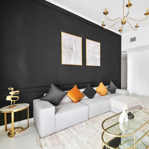 Recline in style on the L-shaped sofa against the striking black feature wall