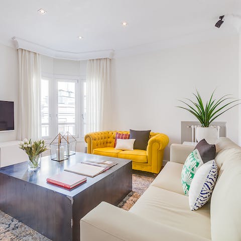 Relax with a glass of Spanish wine in the bright living room after a day of exploring the city