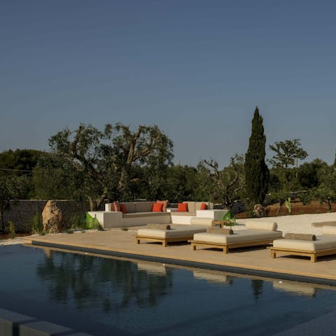 Bag a poolside lounger and enjoy the greenery of olive trees around you