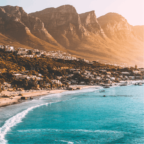 Visit the stunning beaches of Cape Town, featuring an incredible backdrop of mountains