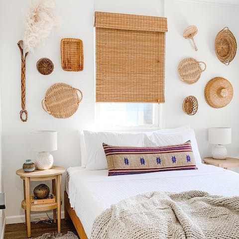 Wake up ready for another day of sun and sand in the beach-vibe master bedroom
