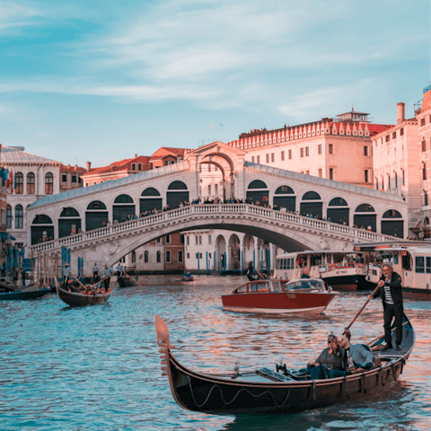 Glide under the historic Rialto Bridge on a gondola