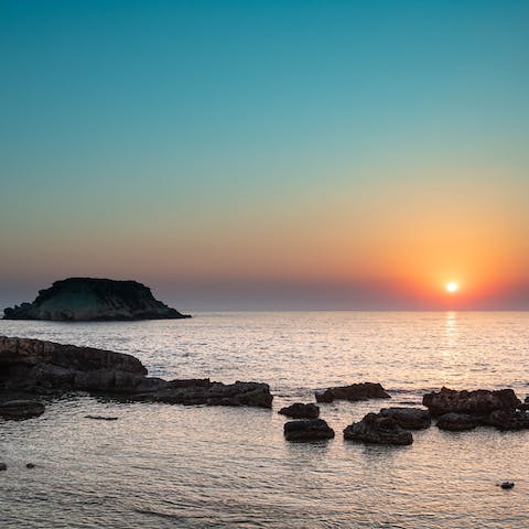 Watch the sunset from nearby Agios Georgios Beach