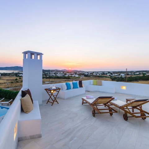 Watch the sun set over the Aegean Sea from the balcony