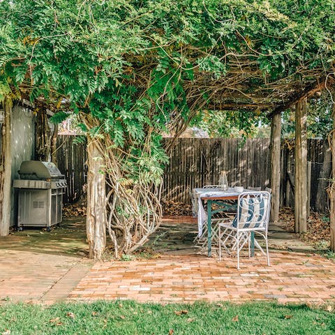 Fire up the barbecue and dine under the Wisteria covered pergola 