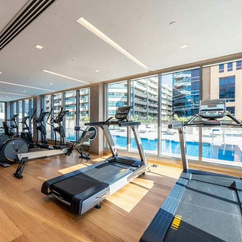 Enjoy a workout in the communal gym with a motivating view of the swimming pool 