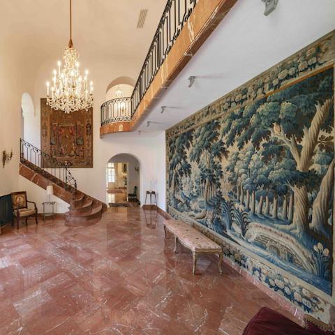 Admire the grand hallway, with its chandelier and tapestry