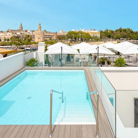 Take in the in the vistas over the Torre del Oro from the communal pool