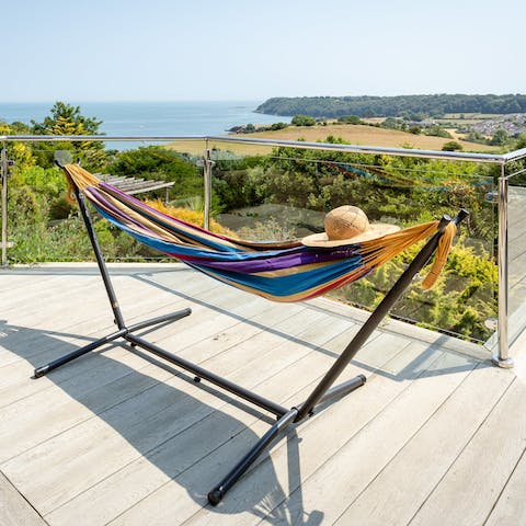 Read a book in the hammock with sea views