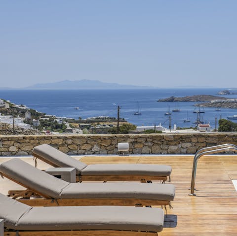 Drink in the view of Ornos Bay from a sun lounger