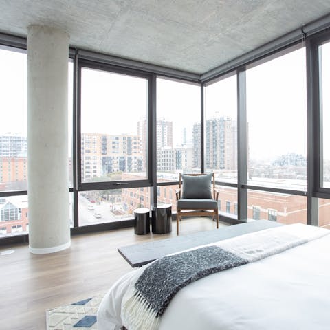 Enjoy floor-to-ceiling city views from the master bedroom