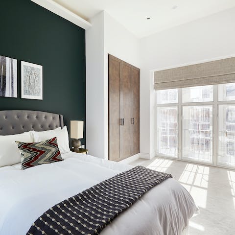 Wake up in the stylish master bedroom with its floor-to-ceiling windows