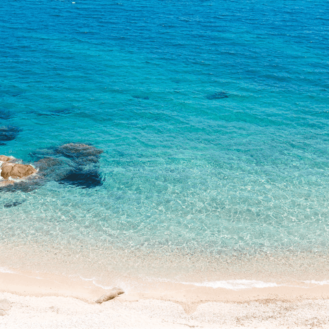 Discover the beautiful coastline of Mykonos – Psarou beach is only a ten–minute drive away
