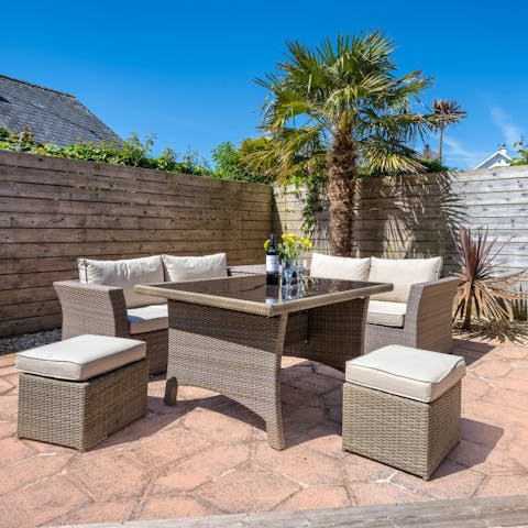 Relax in the sunshine on the pretty patio with a glass of wine in hand