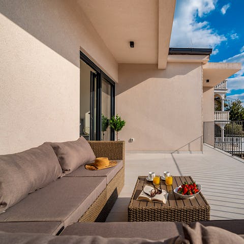 Relax on the balcony's outdoor sofa area for sunny morning coffees and bowls of fresh fruit