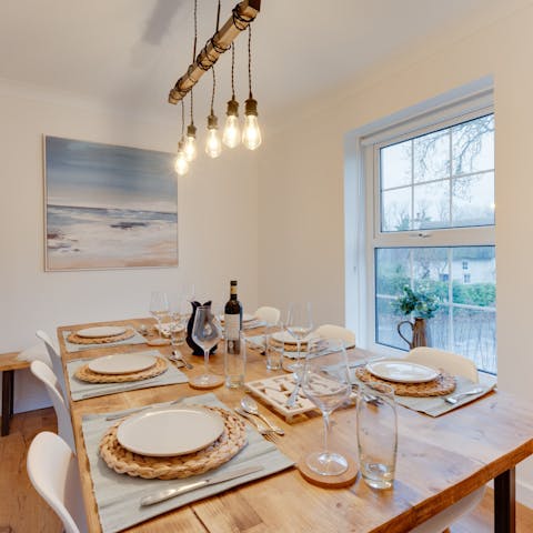 Gather around the large dining table for relaxed dinners and drinks at home, while the low hanging light fixture casts a warm light