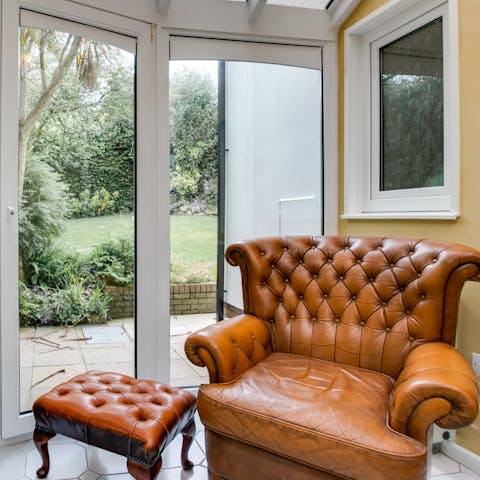 Take a moment to yourself in the bright conservatory to catch up on your book on the grand armchair