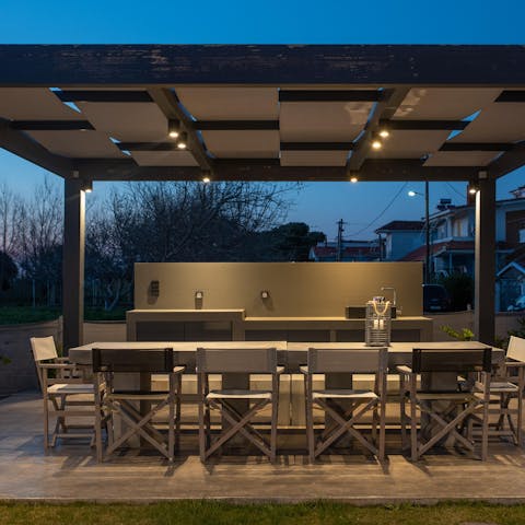 Gather round the outdoor dining table at twilight for a barbecue