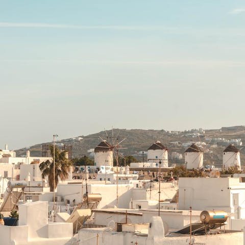 Stroll six minutes to visit the iconic Windmills of Mykonos at sunset