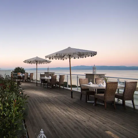 Tuck into a sumptuous dinner looking out over Toroneos Bay