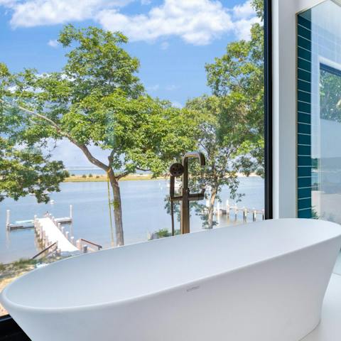 Soak in the bath tub with views across the water 