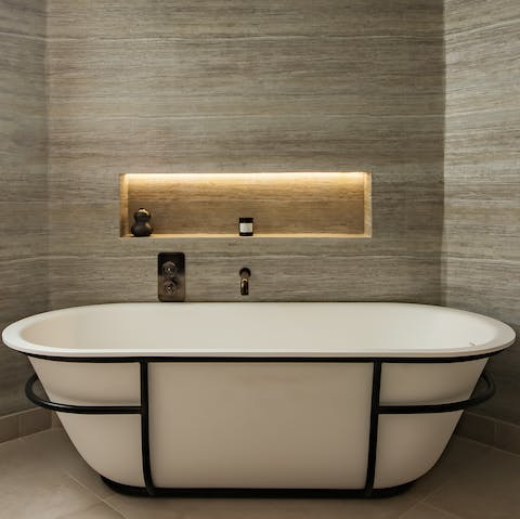 Sink back into the freestanding bathtub's soothingly warm water