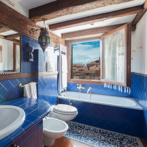 Enjoy a relaxing soak in the blue-tiled bathtub whilst admiring the views