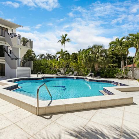 Go for a dip in the communal resort-style pool surrounded by palm trees