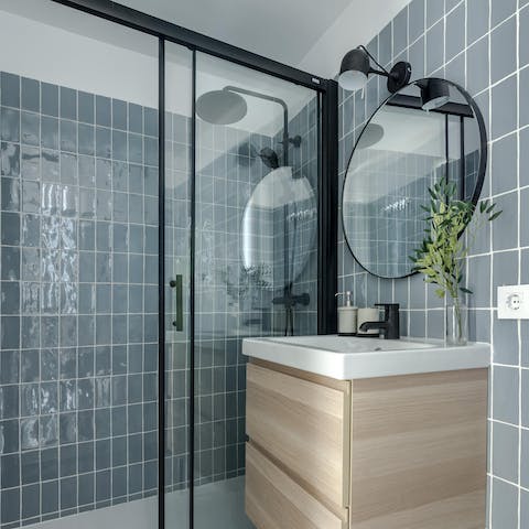 Start mornings with a relaxing soak under the blue-tiled bathroom's rainfall shower