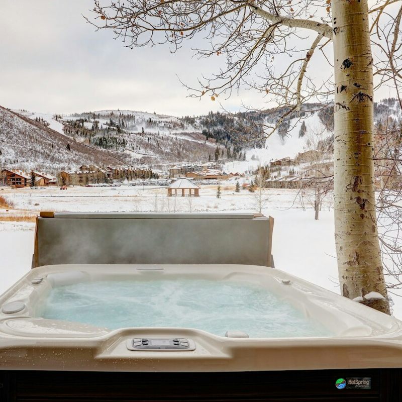 Soak in the hot tub overlooking the snowy mountains