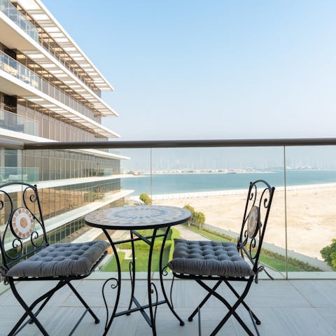 Admire the views over the Persian Gulf from the private balcony