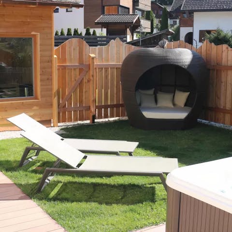 Relax in the garden on the day bed before enjoying a soak in the hot tub