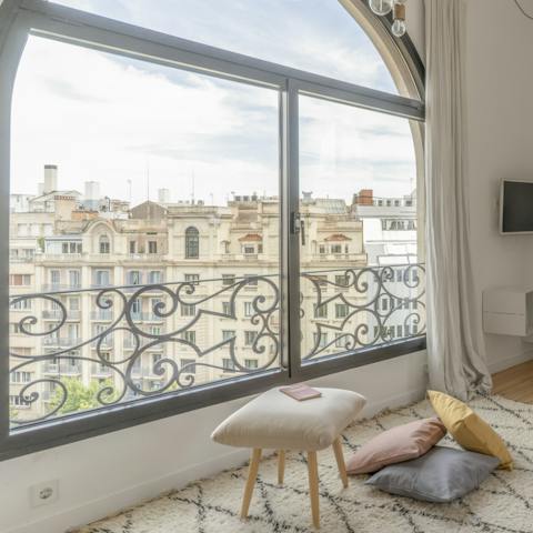 Lounge by the large arched window overlooking the vast expanse of Avenida Diagonal