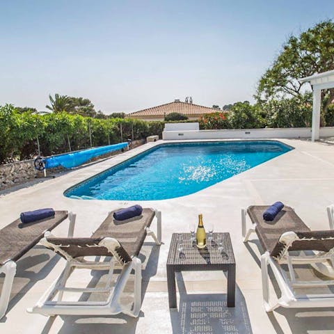 Sip on glasses of crisp white wine while lazing on loungers beside the pool