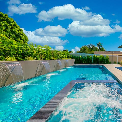 A pool with a spa and waterfall features