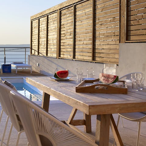 Enjoy alfresco meals by the poolside dining table 
