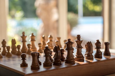 Go tech-free and teach your kids how to play chess, while you escape the midday sun