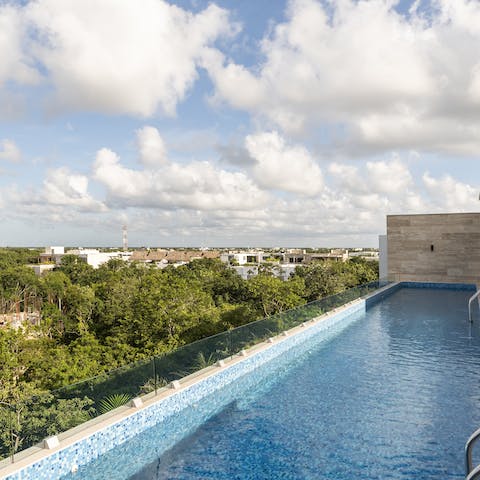 Admire views of the Tulum jungle from the communal rooftop pool